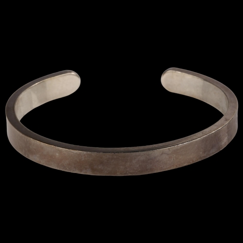 1402 - A late 20th century silver torque bangle, maker's marks RAA, hallmarks London 1981, band width 8mm, ... 