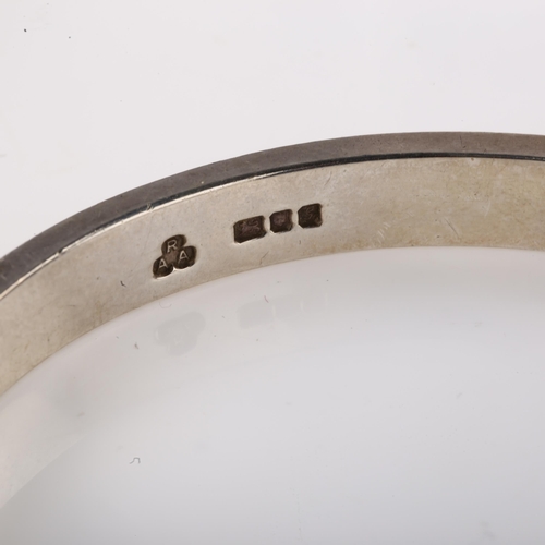 1402 - A late 20th century silver torque bangle, maker's marks RAA, hallmarks London 1981, band width 8mm, ... 