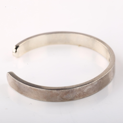 1402 - A late 20th century silver torque bangle, maker's marks RAA, hallmarks London 1981, band width 8mm, ... 