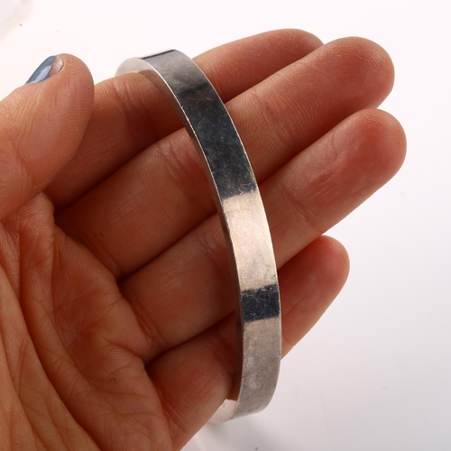 1402 - A late 20th century silver torque bangle, maker's marks RAA, hallmarks London 1981, band width 8mm, ... 