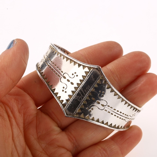 1416 - A Scandinavian Viking Revival bangle, unmarked silver settings with relief embossed decoration, sett... 