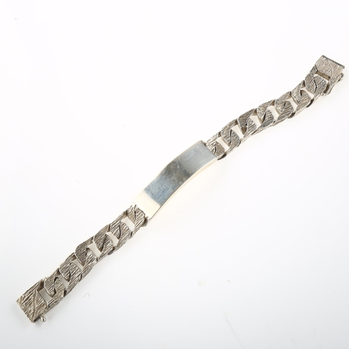 1439 - A heavy silver identity bracelet, textured and polished flat curb links, maker's marks R Co, hallmar... 