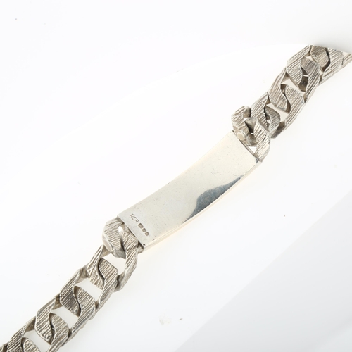 1439 - A heavy silver identity bracelet, textured and polished flat curb links, maker's marks R Co, hallmar... 