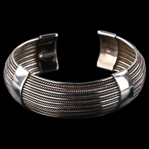 1482 - A Continental sterling silver wirework torque bangle, band width 19mm, internal circumference approx... 