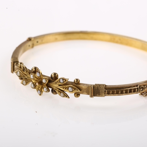 1357 - A Victorian 15ct gold split pearl hinged bangle, with flowerhead motif, internal circumference 16cm,... 