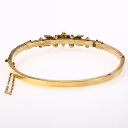 1357 - A Victorian 15ct gold split pearl hinged bangle, with flowerhead motif, internal circumference 16cm,... 