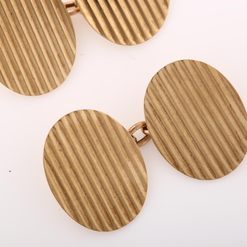 1365 - A pair of late 20th century 9ct gold cufflinks, oval panels with fluted decoration, maker's marks E ... 