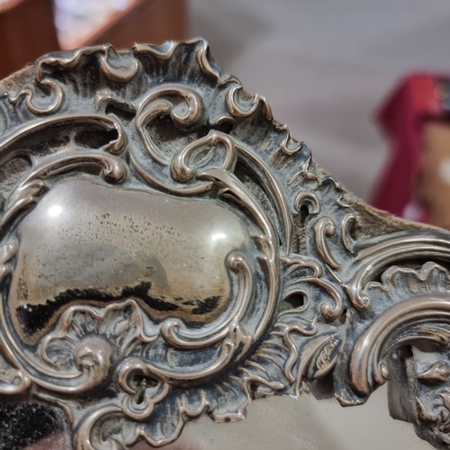 1579 - A large Edwardian silver-fronted dressing table mirror, with relief embossed foliate decoration and ... 