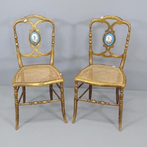 2002 - A Pair of antique salon chairs, with gilded finish, featuring cane seats and hand painted ceramic fi... 