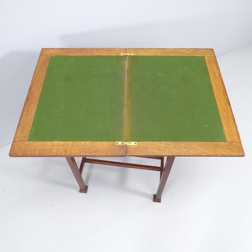 2124 - An Arts & Crafts oak fold over card table. 54x74x39cm.