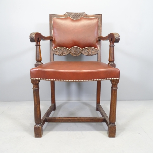 2520 - An antique carved oak and studded leather upholstered open arm desk chair.