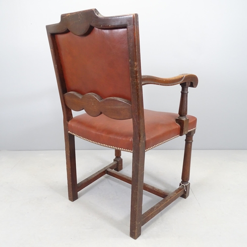 2520 - An antique carved oak and studded leather upholstered open arm desk chair.