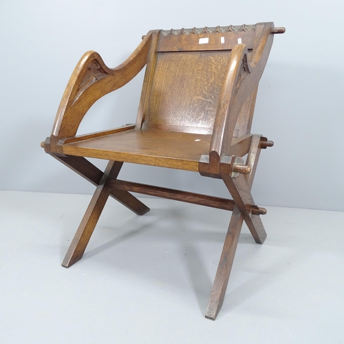 2106 - An antique oak Glastonbury chair with carved top rail and arms.