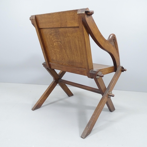 2106 - An antique oak Glastonbury chair with carved top rail and arms.