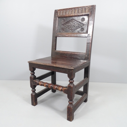 2151 - A 17th century and later panelled oak hall chair with carved back and turned stretcher.