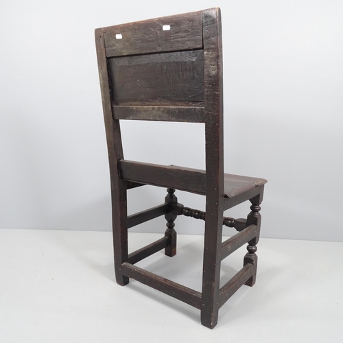 2151 - A 17th century and later panelled oak hall chair with carved back and turned stretcher.