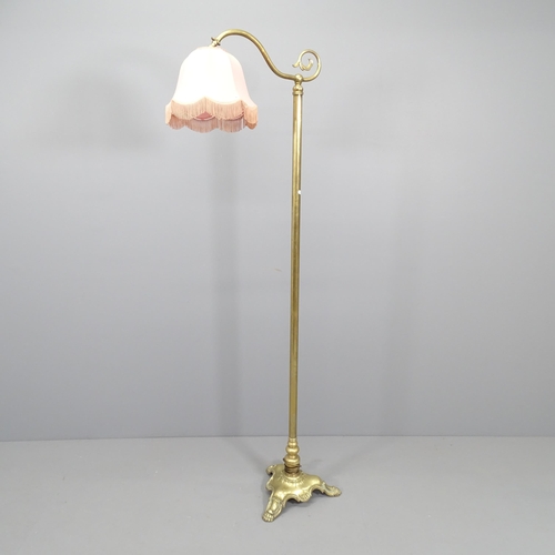 2180 - A Brass standard lamp in the manner of Christopher Wray, on tripod base. Height 170cm.