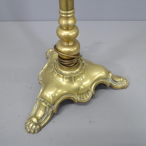 2180 - A Brass standard lamp in the manner of Christopher Wray, on tripod base. Height 170cm.