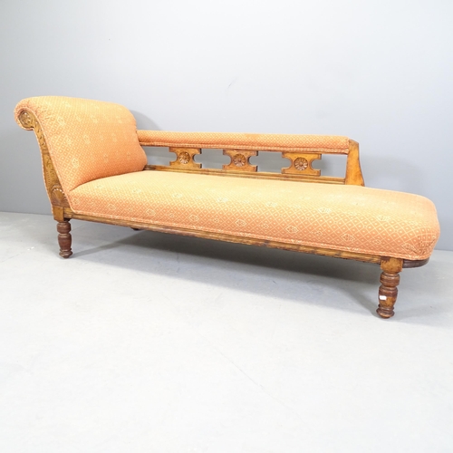 2530 - An Arts and Crafts oak and upholstered chaise longue, with carved decoration.170x70x64cm