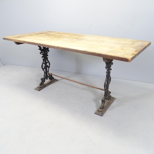 2554 - An oak-topped dining table on cast iron base. 151x71x75cm.