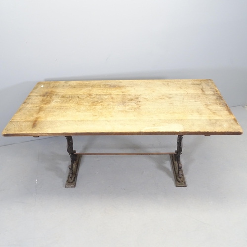 2554 - An oak-topped dining table on cast iron base. 151x71x75cm.