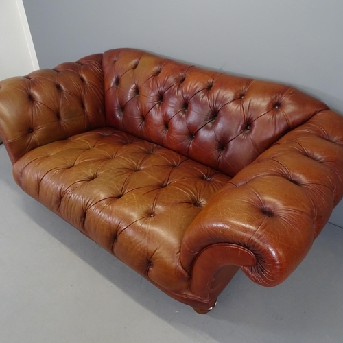 2575 - A button back leather upholstered Chesterfield sofa with rollover arms. 205x83x100cm