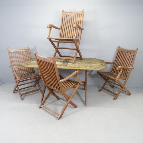 2587 - A weathered teak folding garden table, 150x71x86cm, and four teak folding chairs, with label for Sca... 