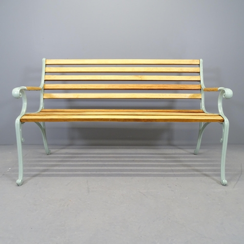 2588 - A teak slatted garden bench with cast iron ends. 136x83x64cm