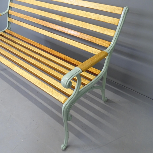 2588 - A teak slatted garden bench with cast iron ends. 136x83x64cm