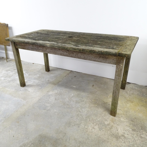 2592 - A weathered teak garden table. 152x73x76cm.