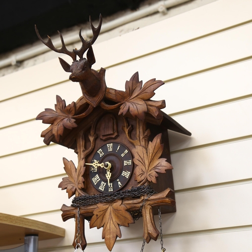 90 - A Black Forest carved cased cuckoo clock, complete with cone weights and pendulum, clock height 50cm