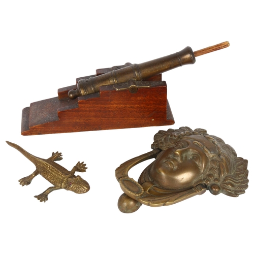 198 - A brass table cannon with ramrod, a brass lizard, and a cast-brass door knocker (Medussa)