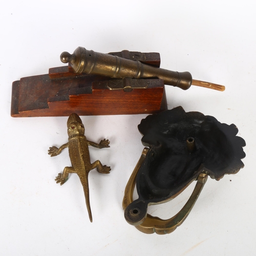 198 - A brass table cannon with ramrod, a brass lizard, and a cast-brass door knocker (Medussa)