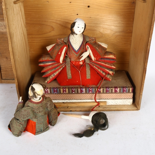 451 - A pine box containing a Japanese costume doll on stand, a doll's head, and another dressed doll, box... 