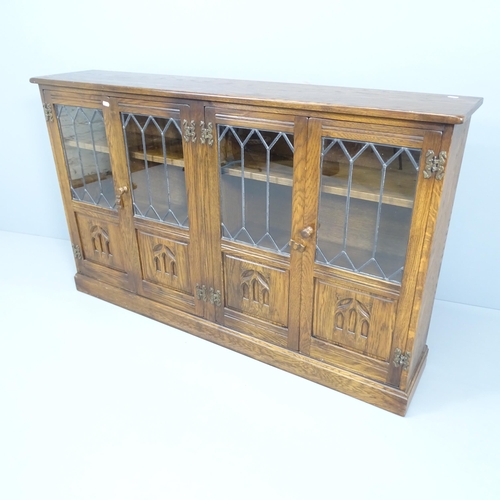 2197 - A reproduction oak four door bookcase, with leadlight glazed panels, four adjustable shelves and lab... 