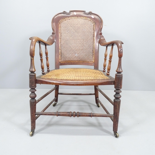 2212 - An 1920s walnut desk chair with cane seat and back panel.