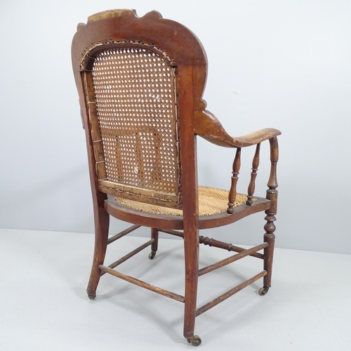 2212 - An 1920s walnut desk chair with cane seat and back panel.