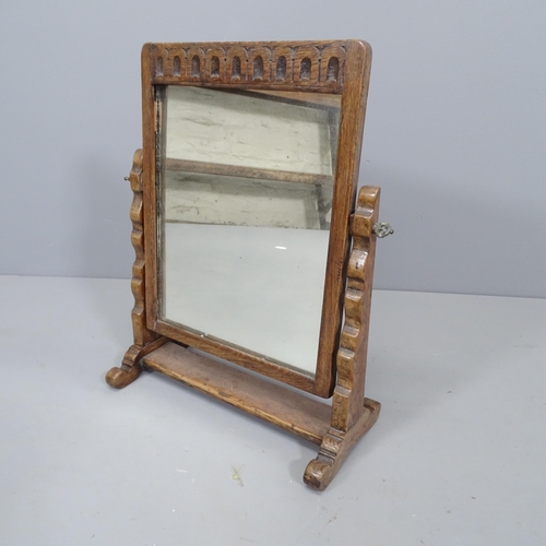 2263 - An early 20th century oak framed swing-toilet mirror with carved decoration. 43x50cm