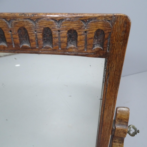 2263 - An early 20th century oak framed swing-toilet mirror with carved decoration. 43x50cm