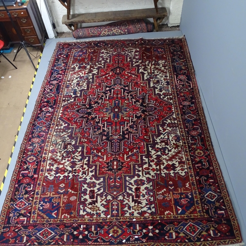 2302 - A red-ground Persian Heriz carpet. 330x228cm