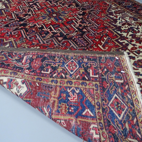 2302 - A red-ground Persian Heriz carpet. 330x228cm