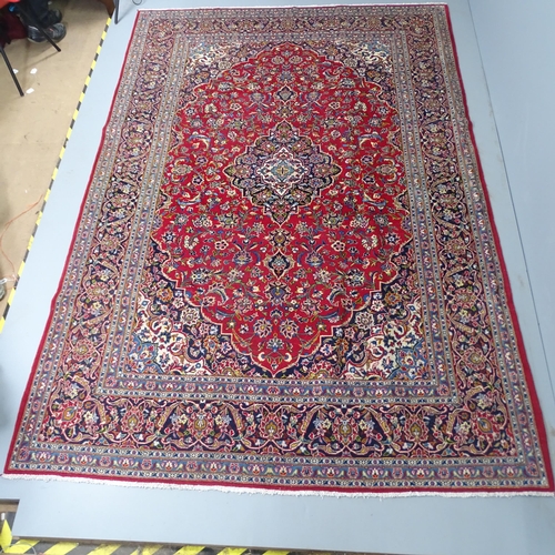 2316 - A red ground Tabriz carpet. 315x218cm