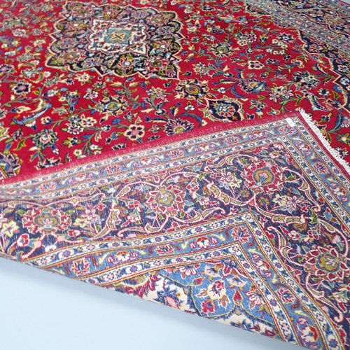 2316 - A red ground Tabriz carpet. 315x218cm