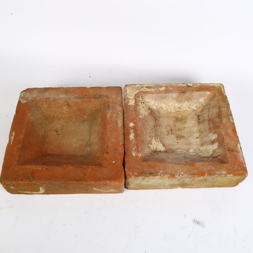 552 - A pair of decorative terracotta bricks, with floral designs, 22.5cm