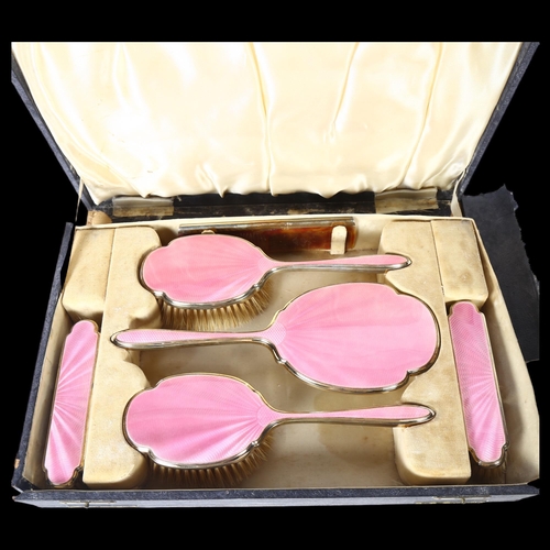 1008 - WALKER & HALL - a George V silver and pink enamel dressing table brush and mirror set, in fitted cas... 