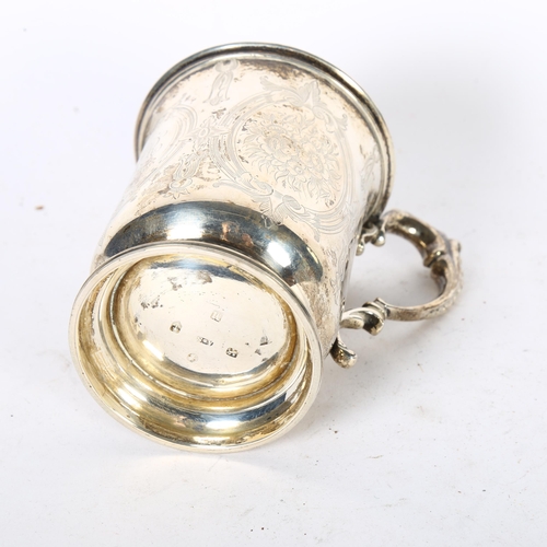 1041 - An ornate Victorian silver tankard on turned foot, with engraved decoration, with monogram HHR and d... 