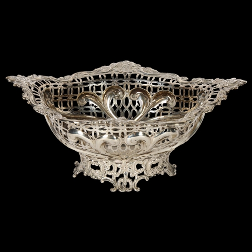 1042 - WILLIAM COMYNS & SONS - a Victorian Art Nouveau silver basket, having scrolled embossed stylised and... 