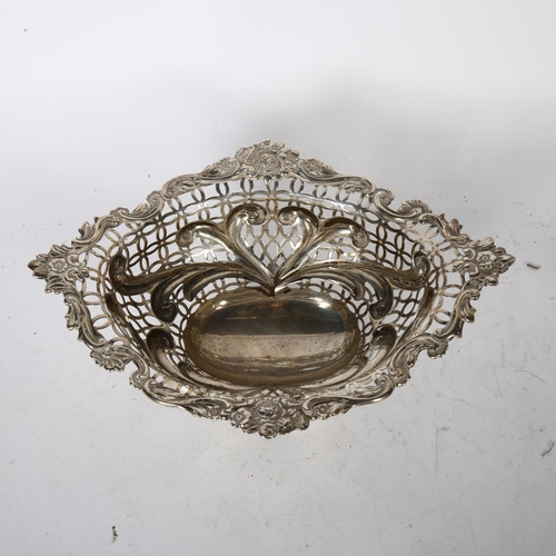 1042 - WILLIAM COMYNS & SONS - a Victorian Art Nouveau silver basket, having scrolled embossed stylised and... 