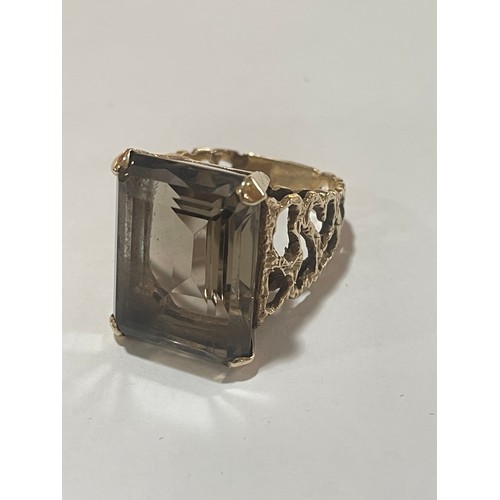 1167 - A large 1970s smoky quartz dress ring, unmarked 9ct gold settings with pierced and textured bark des... 