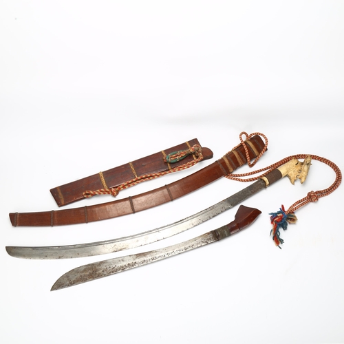 13 - 2 Mandau Dayak Borneo swords, circa 1900, 1 with elaborate carved handle, both with original wooden ... 